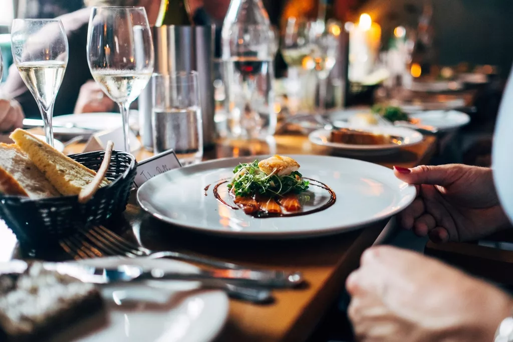 Table de dîner dressée avec assiettes et verres de vin