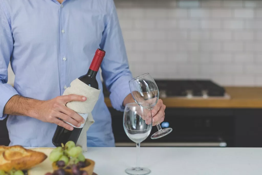 Homme présentant une bouteille de vin